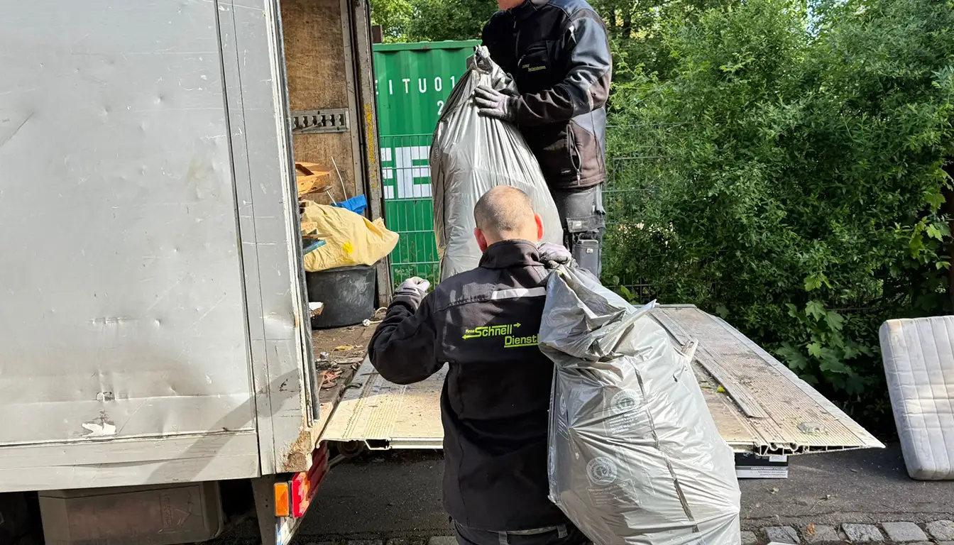 Wohnungsauflösung in Stuttgart – ein Mitarbeiter von Schnell Dienstleistungen reicht Säcke zur Laderampe, ein Kollege nimmt sie auf dem Lkw entgegen